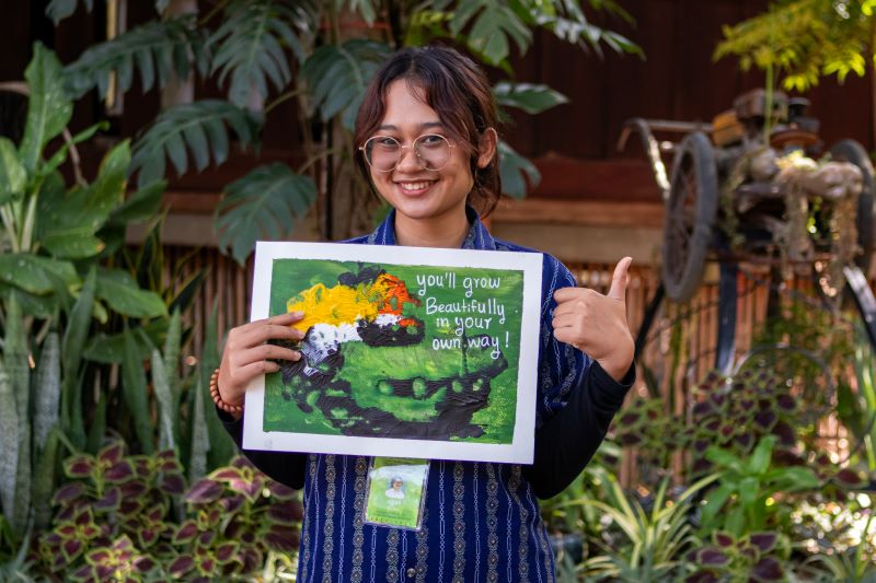 A life skills student at Phare Ponleu Selpak holds up their artwork