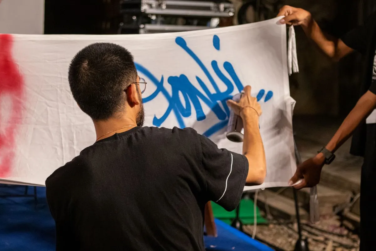 Fonki sprays his name in blue grafitti as part of the S'Art Urban Arts Festival opening ceremony