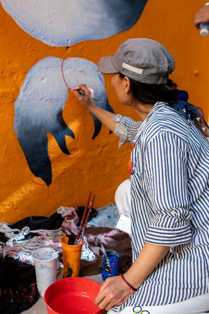 A mural artist from Phare Ponleu Selpak paints a mural for the S'Art festival