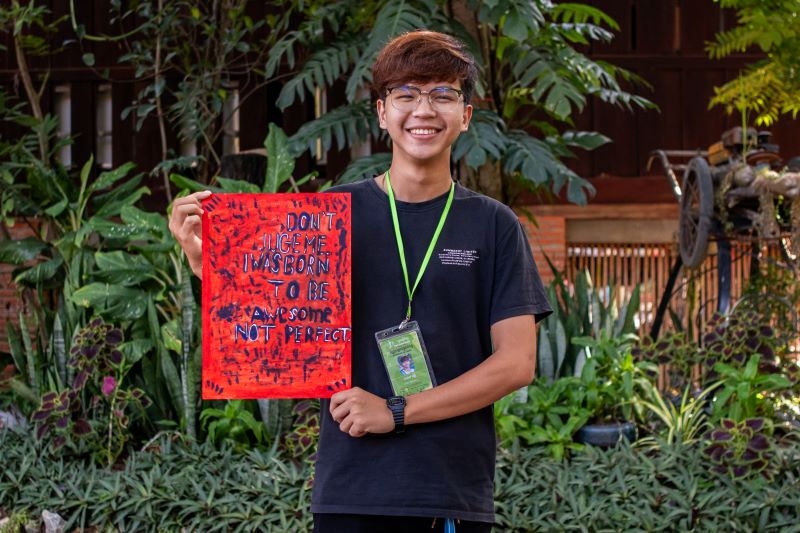 A life skills student at Phare Ponleu Selpak holds up their artwork