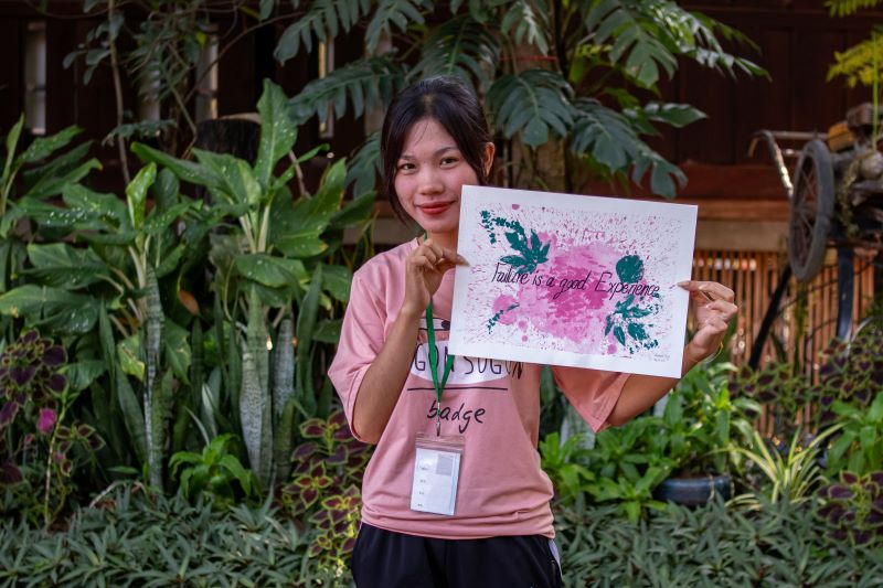 A life skills student at Phare Ponleu Selpak holds up their artwork