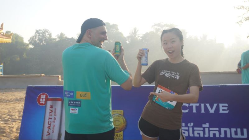 Enthusiastic runners posing with the sponsor logos and in-kind donations at the Sangker River Run